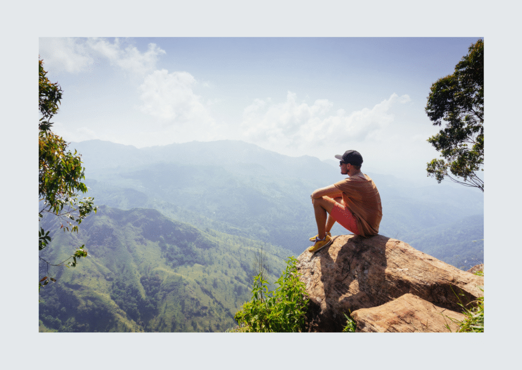 traveller sitting on the edge of a mountain